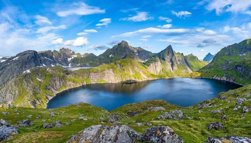 Mountain landscape with lake Tennesvatnet, at sunrise, in the back peak of Hermannsdalstinden,