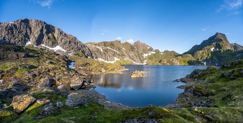 Mountain landscape with lake Krokvatnet, in the back mountain peak Hermannsdalstinden, at sunrise,