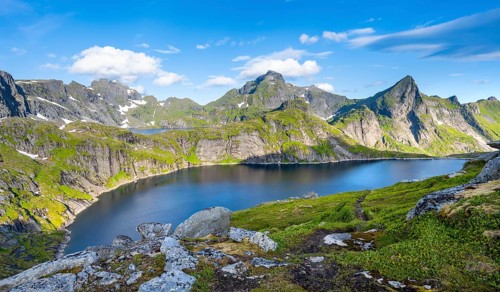 Mountain landscape with lake Tennesvatnet, at sunrise, in the back peak of Hermannsdalstinden,