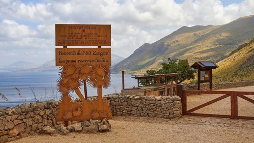 Welcome sign, stone wall, green mountains, cloudy sky, Zingaro, national park, nature reserve,