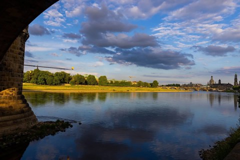 View through the arches of the Marienbrücke onto the Elbe meadows in Dresden's Old Town with