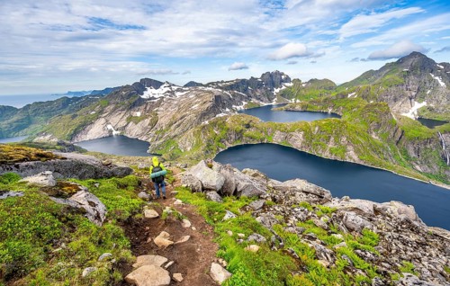 Mountaineers on a hiking trail, mountain landscape with steep rocky mountain peaks and lake