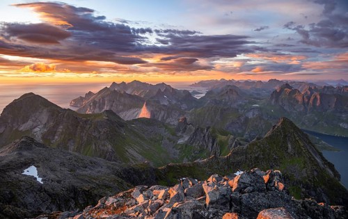 View over mountain top and sea, dramatic sunset, from the top of Hermannsdalstinden, Moskenesöy,