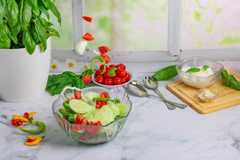 Fresh vegetables on board, salad ingredients, cucumber, tomatoes, basil, pepperoni, onion, garlic,