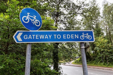 Blue traffic sign in the rain, cycle path, original signpost with inscription, Gateway to Paradise,