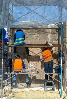 Workers maintaining stonework Eagles and Jaguars platform, Chichen Itza, Mayan ruins, Yucatan,