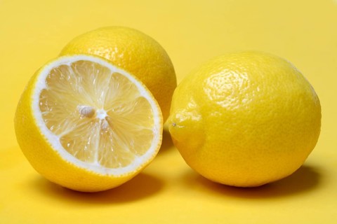Halved lemon against a yellow background, lemon