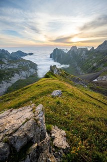 View over Säntis mountains into the valley of Meglisalp at sunrise, Rotsteinpass, high fog in the