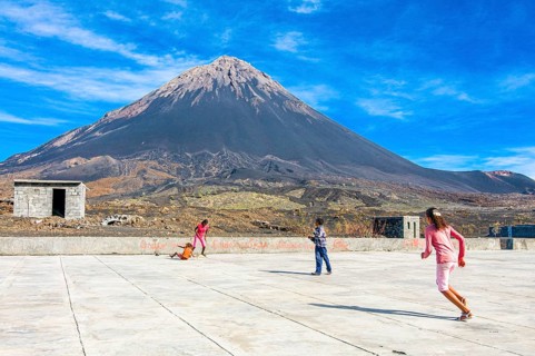 Children playing football, vulcano in background. Fogo. Cabo Verde. Africa