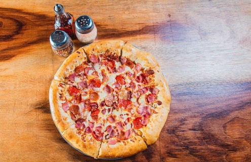 Top view of ham and cheese pizza on wooden table. Ham pizza with cheese edge on wooden background