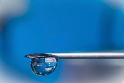 Macro image Covid vaccine, a drop of Moderna vaccine hangs on a vaccine needle
