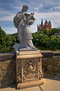Statue of the bridge saint Nepomuk on the Old Lahn Bridge with Limburg Cathedral St. George,