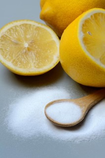 Citric acid in wooden spoon and lemon