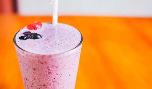 Close up of a strawberry milkshake in blurred background with copy space. Strawberry smoothie with
