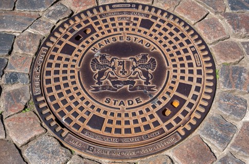 Manhole cover, manhole cover with city coat of arms and cobblestones, Hanseatic City of Stade,