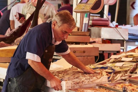 Vendor places box of fish, fish market, old town, Catania, east coast, Sicily, Italy, Europe