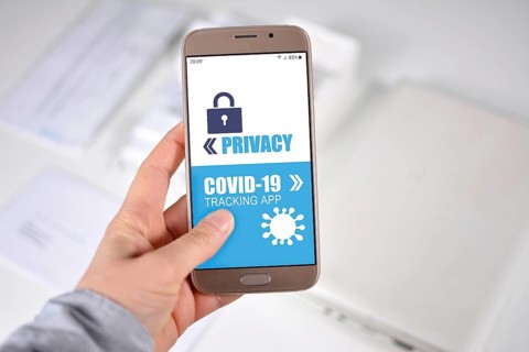 Corona Virus Tracking App privacy concerns concept with hand holding cell phone with application