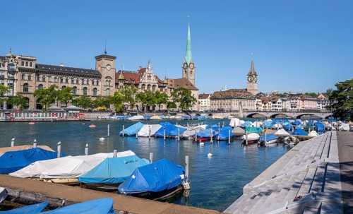 Boats at the jetty in the Limmat, towers of the Fraumünster and St. Peter, Old Town, Zurich,