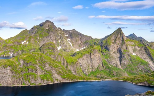 Mountain landscape with lake Tennesvatnet and steep rocky mountain peak with waterfall, peak of