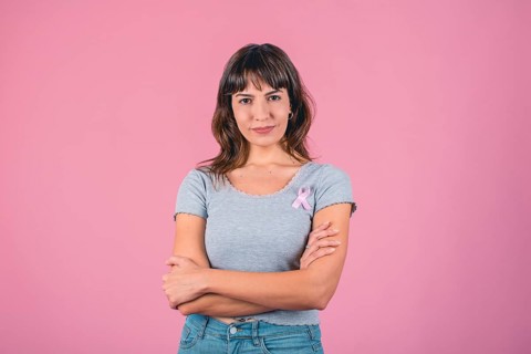 Serious woman wearing pink breast cancer awareness ribbon