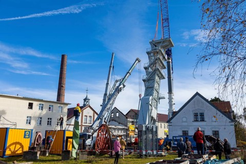 After its restoration, the 34-metre-high winding tower of the rich mine has been lifted back into