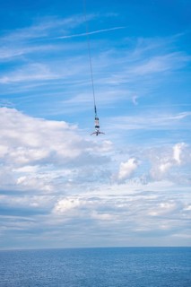 Bungy jumper on the rope over the sea, The Hague, Netherlands