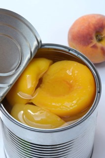 Peach, preserved peach halves with syrup in a tin can