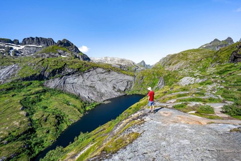 Mountaineers on the hiking trail to Munkebu hut, view of lake Tridalsvatnet and mountain landscape,