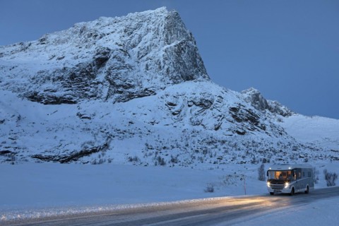 With motorhome in winter on Flakstadveien (E10) in front of the mountain Stortinden