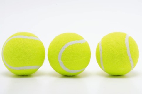 Sports equipment, three yellow tennis balls in a row