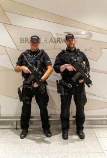 Two armed police officers on duty inside South Terminal, London Gatwick airport, England, UK