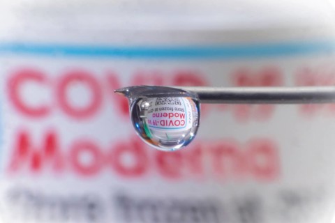 Macro image Covid vaccine, a drop of Moderna vaccine hangs on a vaccine needle