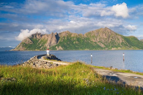 Lighthouse at harbour wall, fishing village Hovden, island Langoya, archipelago Vesteralen, Norway,