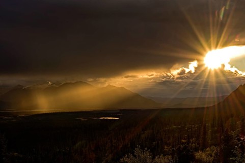 Sun in the evening breaks through the dense cloud cover in the subarctic tundra landscape, Denali