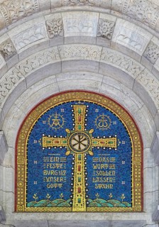 Cross mosaic in the tympanum with the quotation Eine feste Burg ist unser Glauben by Martin Luther,