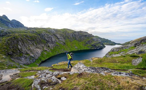 Climbers on a hiking trail, mountain landscape with lake Fjerddalsvatnet, Moskenesoya, Lofoten,