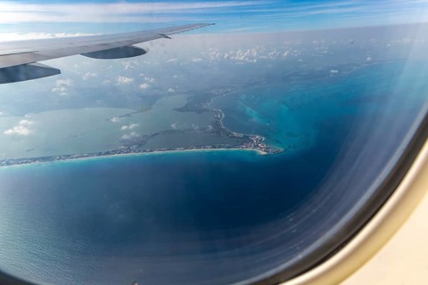 Aerial view through plane window of Caribbean coastline buildings in the hotel zone, Cancun,