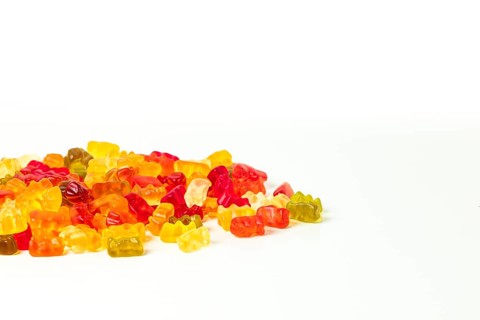 Group of different coloured gummy bears, on white, copying room