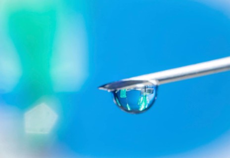 Macro image Covid vaccine, a drop of Moderna vaccine hangs on a vaccine needle