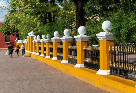 Three women walking along side of main zocalo park in city centre, Valladolid, Yucatan, Mexico,