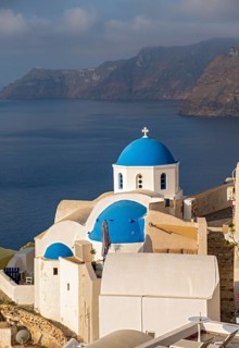 Blue-domed Church of Agios Nikolaos and view of caldera, Ia, Oia, Santorini, Greece, Europe