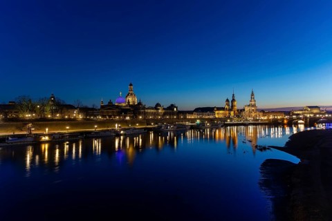 Skyline of Dresden's old town, illuminated in the evening. On the terrace bank on the Elbe, the