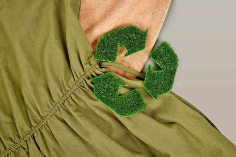 Environmental friendly produced clothing with recycling arrow symbol made out of grass