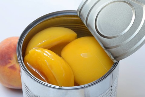 Peach, preserved peach halves with syrup in a tin can
