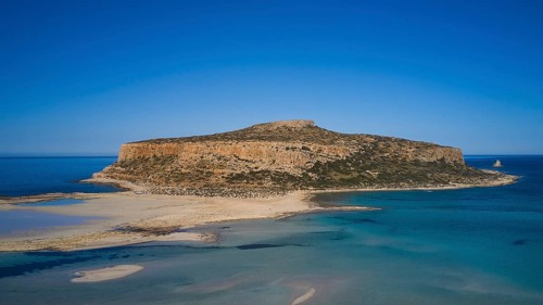 Aerial view of a rocky island with shallow coastline and blue water, Gramvoussa, Gramvoussa