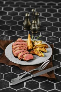 Sliced duck breast cooked to a perfect medium-rare served with caramelised apples and pears on a