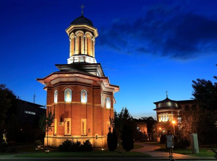 Illuminated church at night with a high tower, blue sky and visible windows. Craiova, Krajowa,