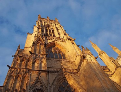 Side view of one of the towers at the front of york minster in sunlight against a blue cloudy sky