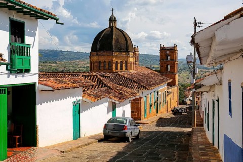 View to a street with typical traditional houses and cathedral in historic town Barichara on a