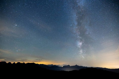 Clear starry sky with visible Milky Way and mountains in the background, Hochalp, Urnäsch,